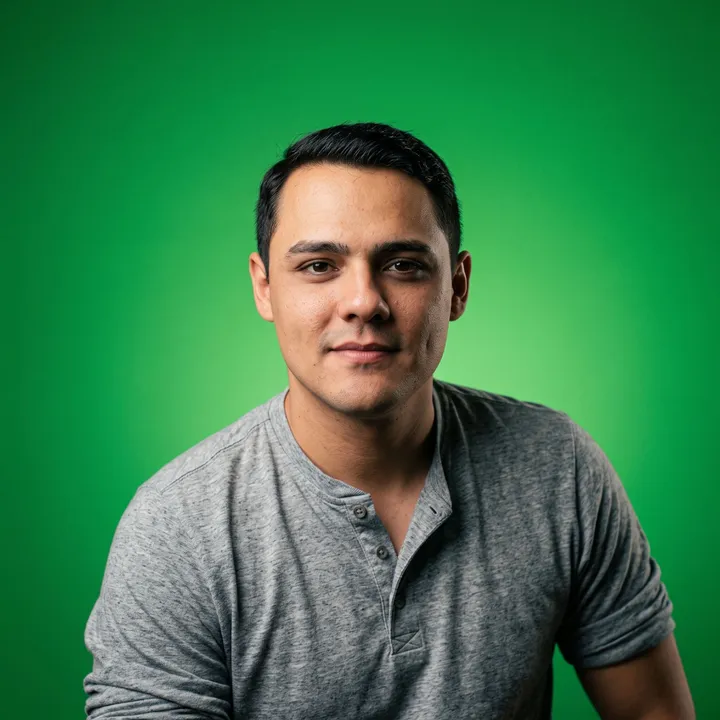 Carlos Apenas in a gray henley shirt, in front of a green background